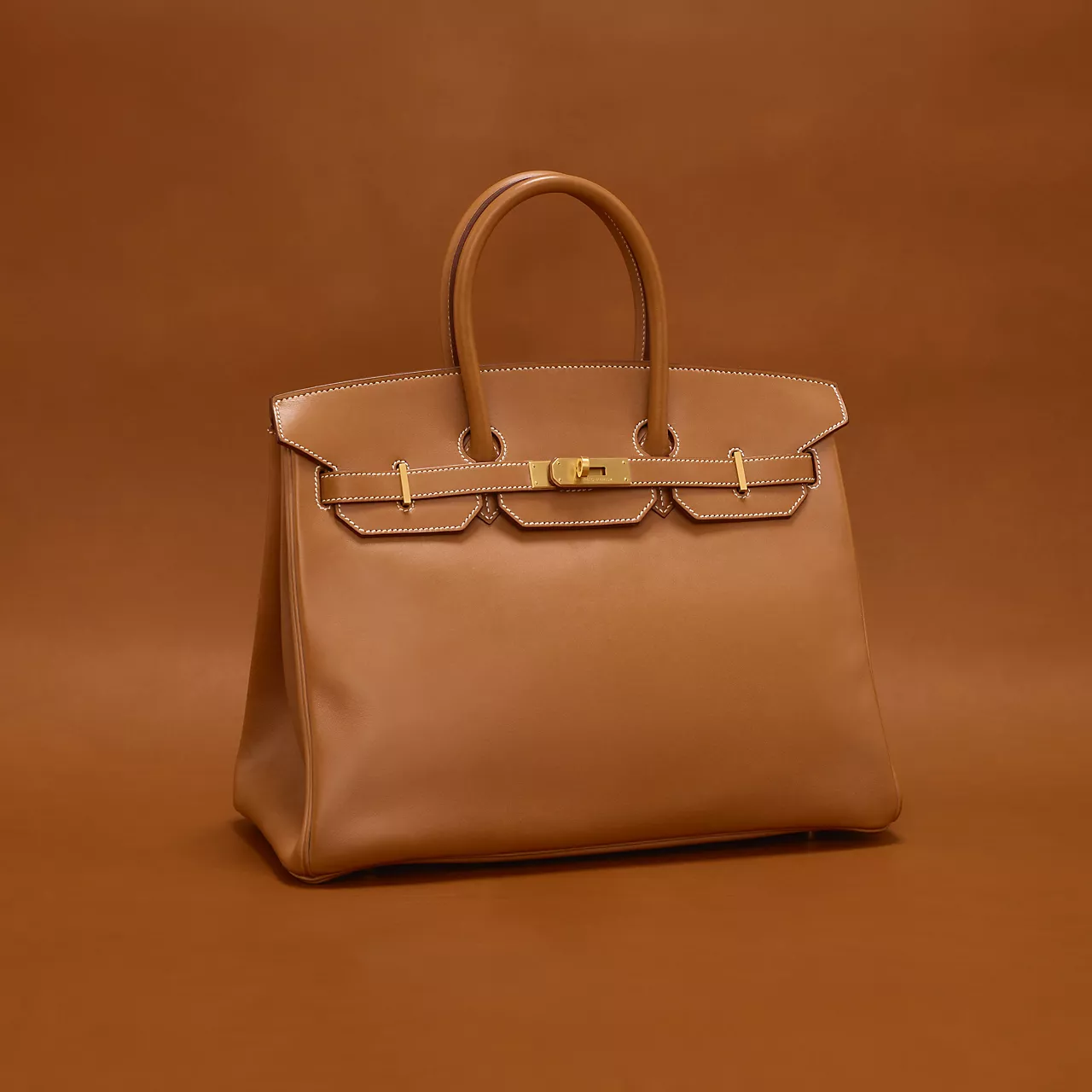 Birkin: Sketched On A Flight To LondonEvery Hermès story eventually arrives at the Birkin, and this one begins mid-air. In 1984, actress Jane Birkin sat beside Jean-Louis Dumas on a Paris-to-London flight, complaining she'd never found a bag practical enough for a young mother. Dumas sketched one on the spot, roomy, rectangular, with a dedicated slot for baby bottles. Availability remains famously restricted even today, and pricing reflects that scarcity: a Birkin 25 or 30 in standard leather generally starts north of ₹11-12 lakh in India, with waitlists, exotic skins, and special orders capable of pushing the number several times over. Birkin: Sketched On A Flight To LondonEvery Hermès story eventually arrives at the Birkin, and this one begins mid-air. In 1984, actress Jane Birkin sat beside Jean-Louis Dumas on a Paris-to-London flight, complaining she'd never found a bag practical enough for a young mother. Dumas sketched one on the spot, roomy, rectangular, with a dedicated slot for baby bottles. Availability remains famously restricted even today, and pricing reflects that scarcity: a Birkin 25 or 30 in standard leather generally starts north of ₹11-12 lakh in India, with waitlists, exotic skins, and special orders capable of pushing the number several times over.
